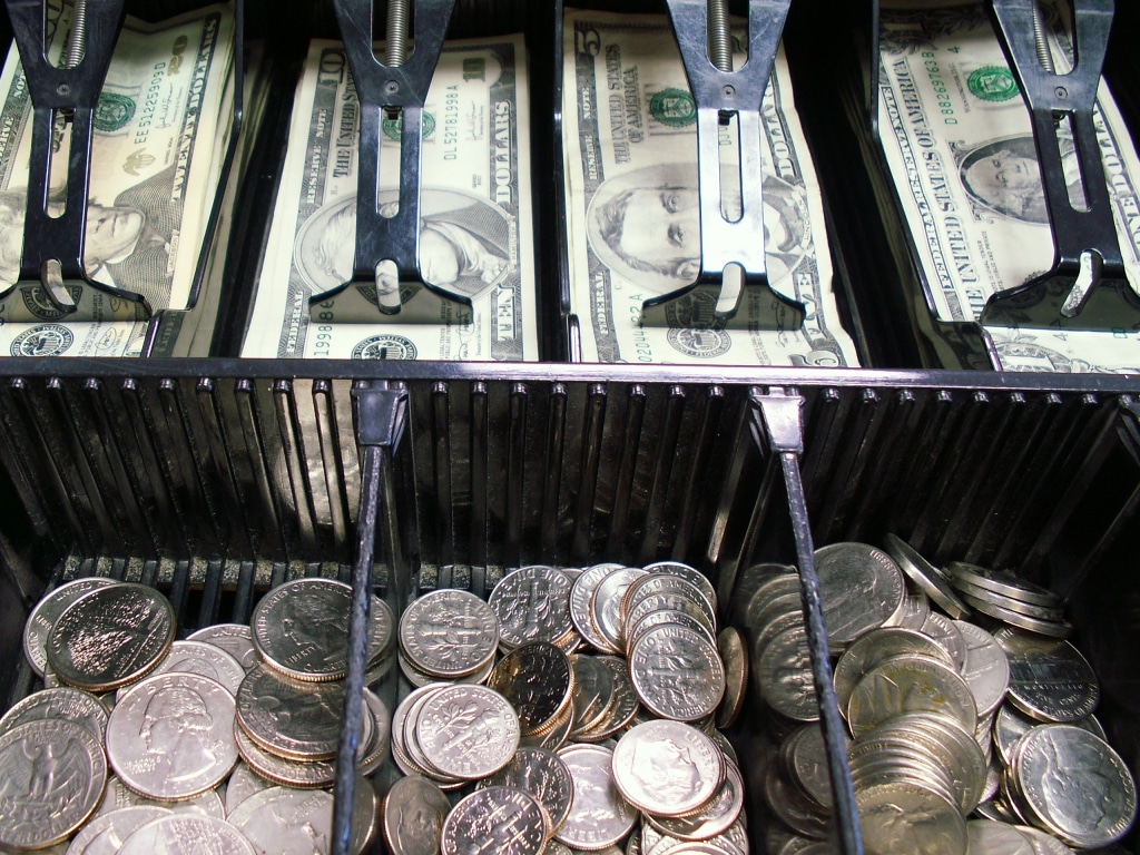 bills and coins in a cash register
